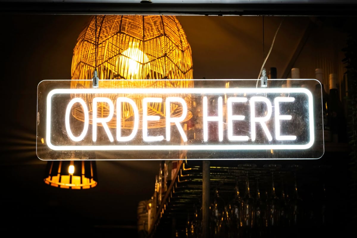 Chữ ORDER HERE bằng đèn neon gắn trên tấm mica trong