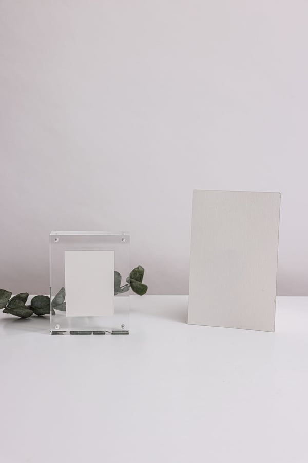 Khung mica trong đứng cạnh tấm thẻ trắng trên bàn