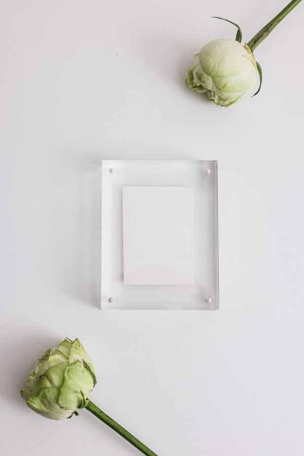 Khối mica trong suốt giữ tấm thẻ trắng đứng trên bàn