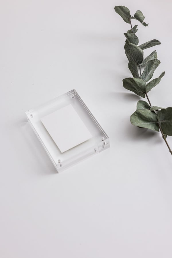 Khung mica trong suốt đứng trên mặt bàn trắng